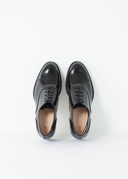 Classic Brogue in black leather with detailed stitching and lace-up design. Perfect accessory for any outfit.